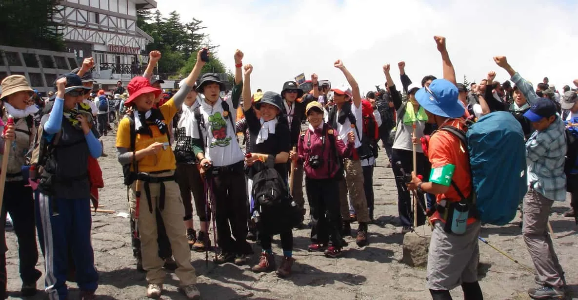 Hikers resting at an 8th-station mountain hut on a Mount Fuji climbing tour with the summit above in Japan