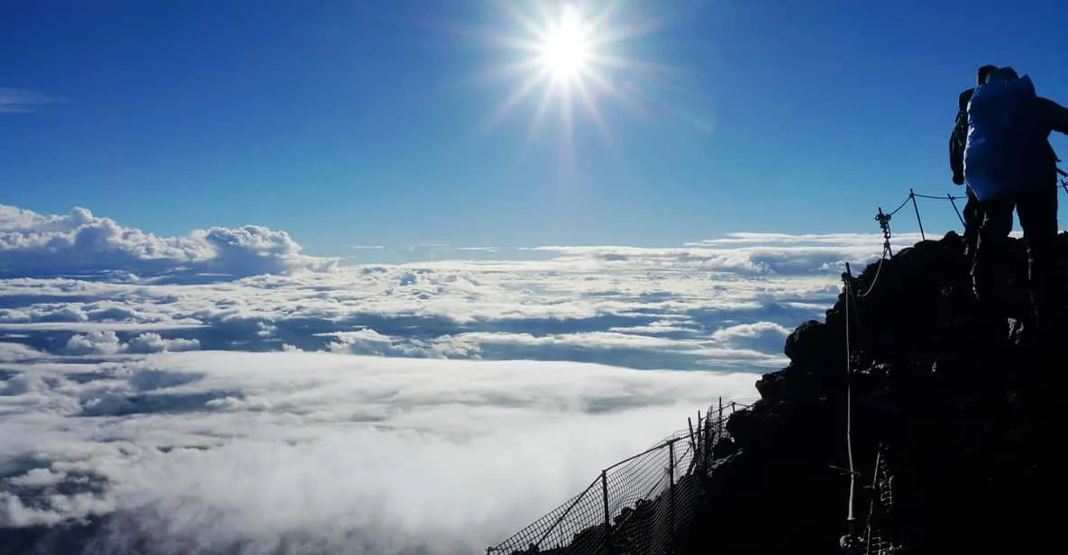 Small group climbing the volcanic upper slope on a Mount Fuji climbing tour toward the crater in Japan